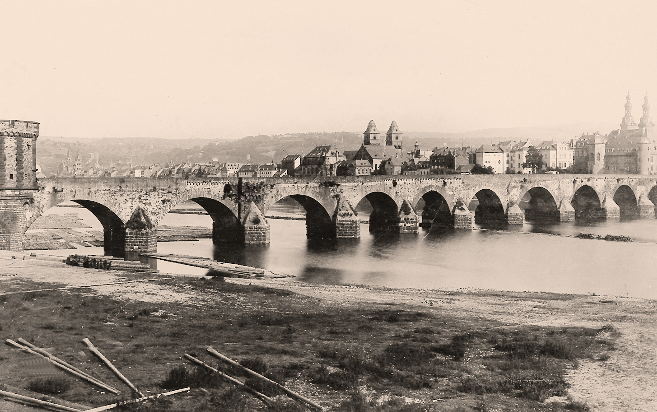 Die Balduinbrücke im späten 19. Jahrhundert. Die beiden Brückentürme waren „Neubauten“ der Koblenzer Stadtbefestigung. Zu dieser Zeit waren die Aufbauten der Barockzeit schon längst verschwunden. Und auch in den folgenden Jahren wurde die Brücke, die einst als eine der ältesten Steinbrücken nördlich der Alpen bewertet wurde, immer wieder verändert. Foto: Otto Kilger/Stadtarchiv (gemeinfrei)