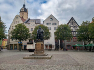 Markt in Jena mit dem "Hanfried", einer Bronzefigur auf dem Markt in Jena zum Gedenken an Johann Friedrich I. von Sachsen, dem Begründer der Universität der Stadt. Das Monument wurde anlässlich der 300-Jahr-Feier der Universität am 18. August 1858 enthüllt.