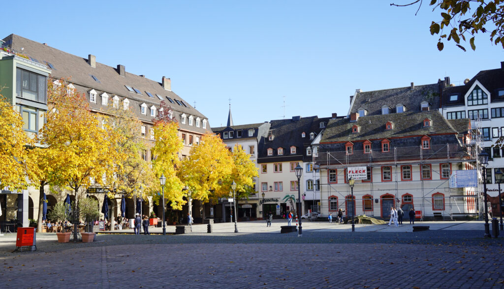 Die nördliche und die östliche Seite des Münzplatzes. Links: Die nach Plänen des Koblenzer Architekten Conrad Reich errichteten Gebäude. Rechts: Das frühere Haus des kurtrierischen Münzmeisters Meydinger.